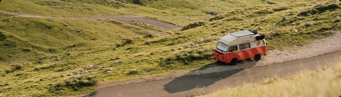 Red and white camper van on a mountain road in Montenegro